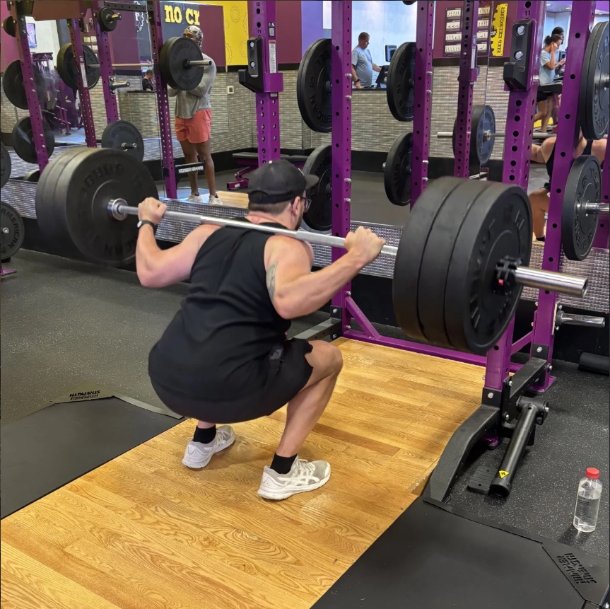 Justin Sovine at the bottom of a heavy back squat in a purple power rack