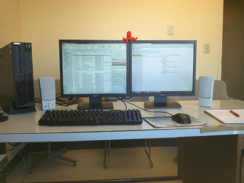 Justin Sovine’s desk at Hebrew Union College in Cincinnati: two monitors, a desktop tower, and a red crocheted octopus sitting on top